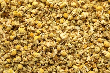 Dry chamomile flowers as background, top view
