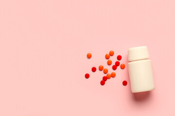 Jar with different pills on pink background