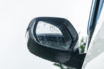 Side rear-view mirror and water droplets on a car.