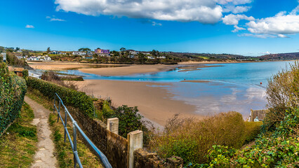 Obraz premium A view down a cliff path towards the estuary at the town of Abersoch, Wales in springtime 