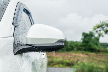 Side rear-view mirror and water droplets on a car.