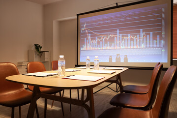Interior of modern conference hall with table, chairs and projector screen
