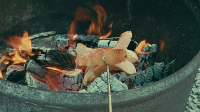Ein Cervelat brutzelt &uuml;ber dem offenen Feuer, eingeritzt und aufgespie&szlig;t &ndash; der Rauch steigt auf, es duftet nach Holz und R&ouml;staromen. Ein echter Schweizer Grillmoment in der Natur.