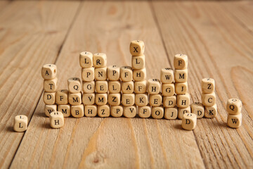 Many cubes with English letters on wooden background