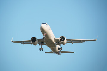 Passenger airplane is preparing to land at the airport. Blue background.