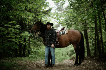 cowboy man with red beard in hat with horse close-up, friendship with animal