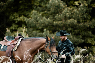 cowboy man with red beard in hat with horse close-up, friendship with animal