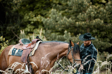cowboy man with red beard in hat with horse close-up, friendship with animal