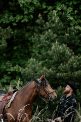 cowboy man with red beard in hat with horse close-up, friendship with animal