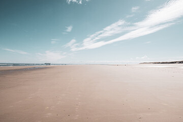 Wide Sandy Beach with Ocean and Horizon &ndash; Tranquil Coastal Scene Under Blue Sky