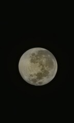 Telescopic view of the Full Moo in the dark night sky.