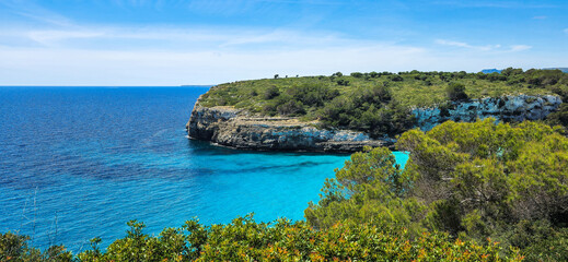 Turquoise bay Cala Romantica with cliff and forest in Mallorca Spain

