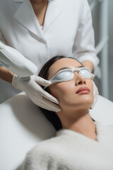 Relaxed young woman enjoying facial massage at spa center