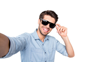 Photo of cheerful positive handsome attractive man taking selfie recording video smiling toothily isolated over grey color background wearing sunglass