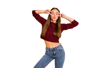 Portrait of lovely woman with eyes closed making v-signs wearing denim jeans burgundy jumper isolated over yellow background