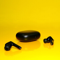 Ear buds on yellow background close-up view 