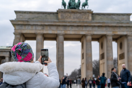 Mujer turista paseando por la Pariser Platz en Berl&iacute;n, Alemania, y tomando una foto en la Puerta de Brandeburgo