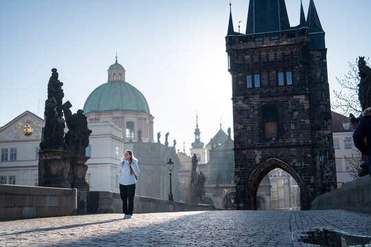 Mujer viajera disfrutando de la maravillosa arquitectura del Puente de Carlos, en la ciudad de Praga, al amanecer