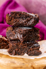 Three fudgy chocolate brownies stacked up.