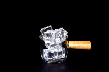 glass with ice cubes on black background closeup view 