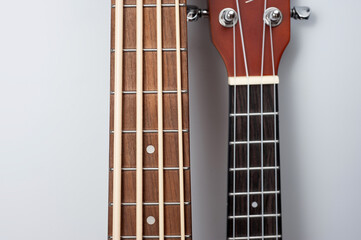 Four-string bass ukulele with wooden body and built-in tuner and pickup.