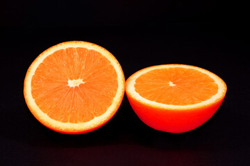 Orange fruit isolated on black background closeup view macro photography