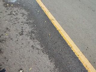 Yellow dividing lines on black asphalt roads for driver safety when crossing