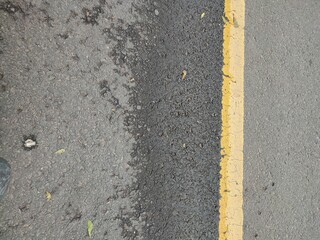 Yellow dividing lines on black asphalt roads for driver safety when crossing
