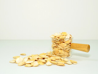 Pumpkin seeds with glass bowl close-up view, Nuts and seeds concept white background