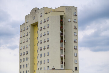 Wysoki budynek mieszkalny na tle pochmurnego nieba