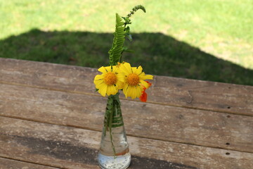 A bouquet of flowers stands in a glass vase.
