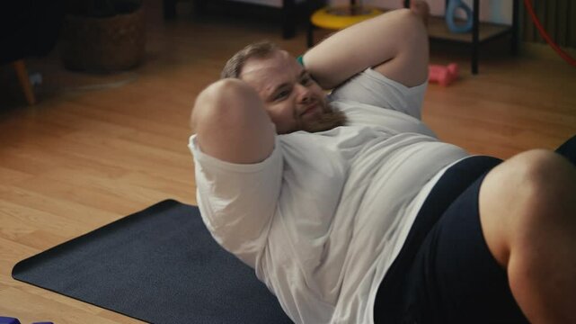 Large-bodied man doing abs exercise to lose belly fat, weight loss motivation