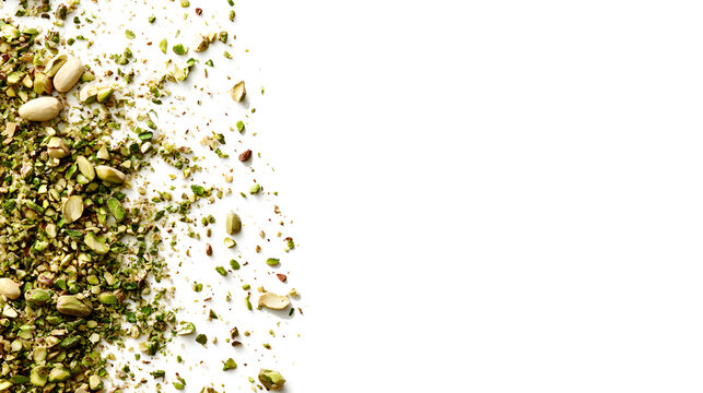 Scattered pistachio nuts, crushed pistachios, green isolated on a white background
