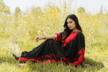 Women wearing red and black dress posing in mustard feilds, shoot for kaar kash