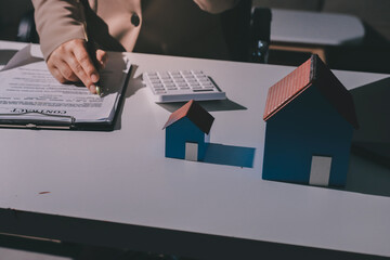 Female Real Estate Broker presenting and advised to .model home and building project detail in the...