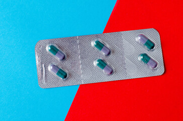 Silver blister pack with white tablets on colorful background