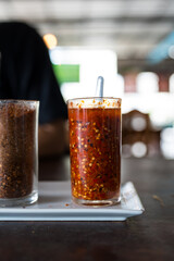 Spicy pickled sliced chili in vinegar for Thai condiments on the table