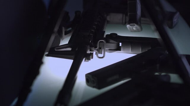 Firearms including rifles and pistols gleam on a lit armory rack  filmed in crisp 4K