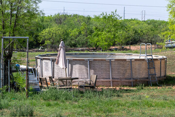 An empty swimming pool and a patio set in a Texas ranch