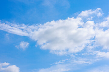 Bright blue sky with fluffy white clouds drifting across, forming a calm and picturesque atmosphere in nature.