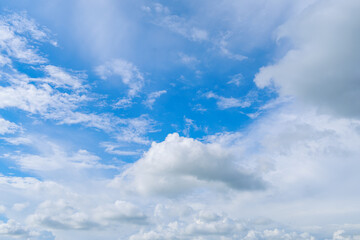 Bright blue sky with fluffy white clouds drifting across, forming a calm and picturesque atmosphere in nature.