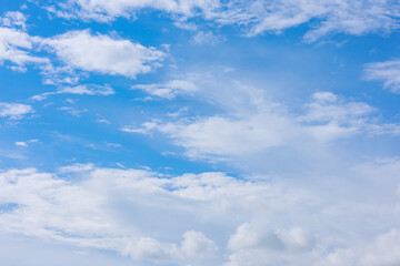 Obraz premium Bright blue sky with fluffy white clouds drifting across, forming a calm and picturesque atmosphere in nature.