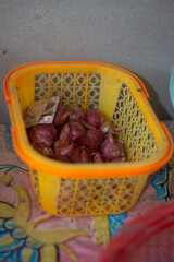 Some onions in the yellow color plastic basket