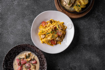 Colorful plates of gourmet food featuring rich pasta, succulent meats, and tantalizing sauces are arranged artfully on a stylish table, inviting diners to indulge and enjoy their evening