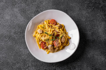 A vibrant plate of pasta captivates with its rich colors and textures, featuring fresh tomatoes and herbs, showcasing culinary artistry in a refined dining experience at dusk