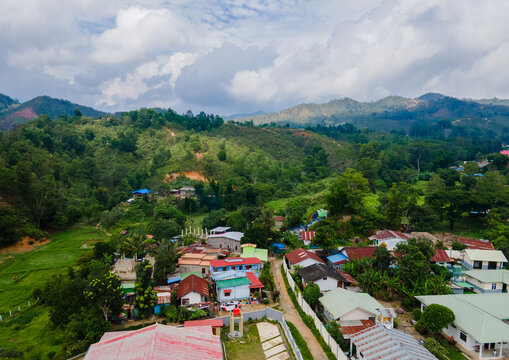 Aerial view of residential area with hills and mountains in the background in Aileu Villa district, urban area in Aileu Municipality, Timor Leste.