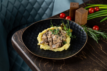 Savor the rich flavors of creamy mushrooms delicately placed atop smooth mashed potatoes, beautifully garnished with fresh herbs. This culinary delight is perfect for an elegant dining experience