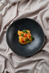 A beautifully plated gourmet dish showcases a delightful mix of colors and textures, garnished with fresh herbs. It promises an enticing culinary experience in an elegant setting