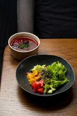 Gourmet dishes featuring a colorful salad of fresh vegetables alongside a bowl of aromatic soup create an inviting and flavorful experience for diners