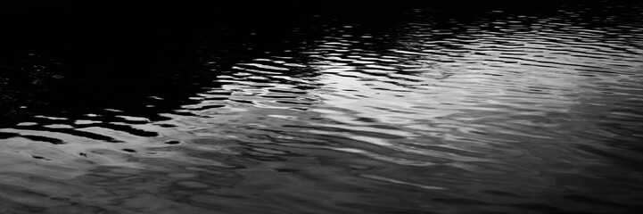 Black white dark gray silver water. Ripples. Reflection of light moonlight. Little waves. Gradient. Abstract. Contrast. Sea surface. Background with space for design. Wide banner. Panoramic. © Наталья Босяк